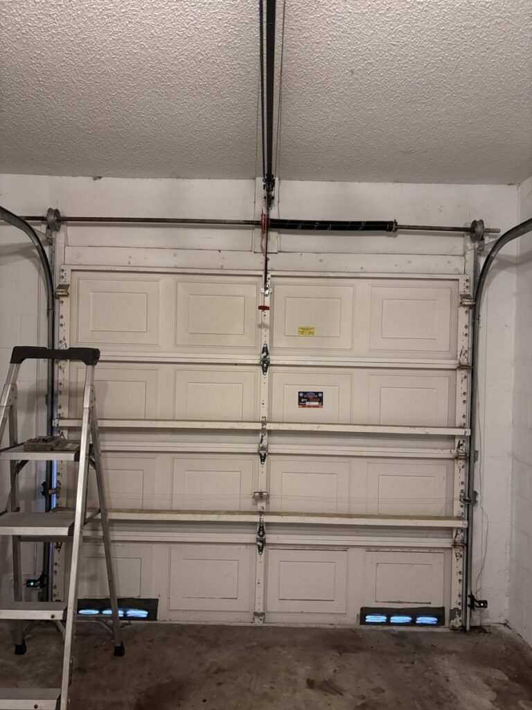 Garage door track and rollers being serviced during a repair call in Boca Raton, FL